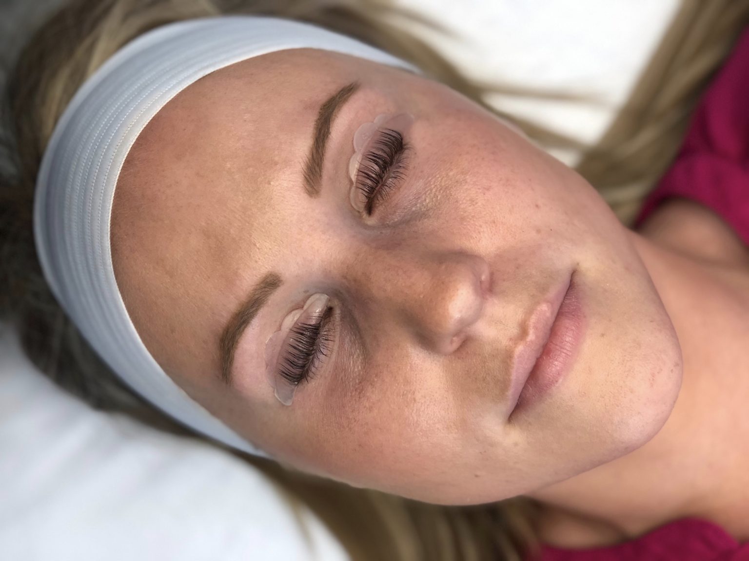 Woman's face getting lash lift service to create longer looking lashes